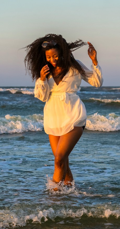erika t kendrick woman paddling in ocean waves smiling-min (2) woman paddling in ocean waves smiling